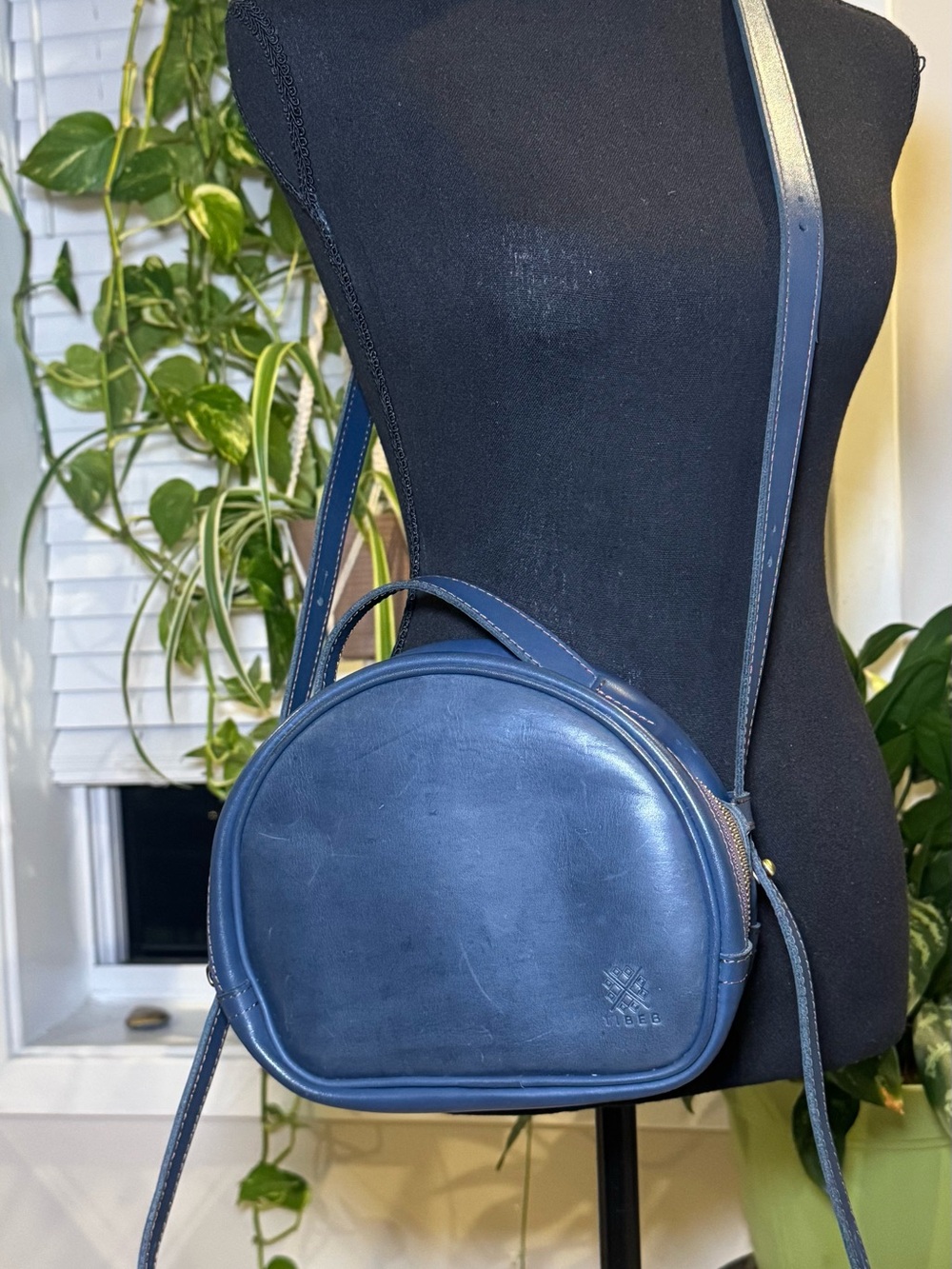 Tibeb Blue leather crossbody bag with gold zipper and hardware.